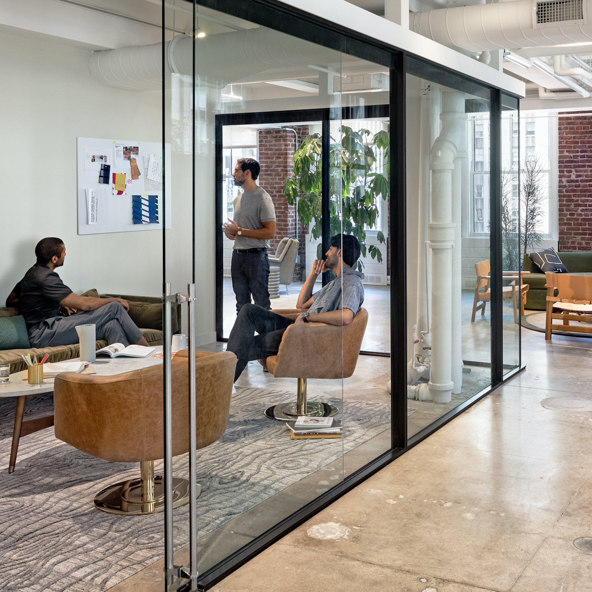 Hallway in artistic office setting with seating that leads to a cubicle area.